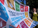 YK:n kestävän kehityksen 17 tavoitetta on kuvattu lippuun eri värisillä neliönmuotoisilla logoilla.