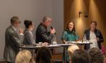 panelistit katsovat kohti juontajia, eläväinen keskustelu meneillään