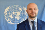 YK-liiton puheenjohtaja Joonas Könttä, taustalla YK:n lippu