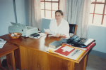 Helena Laukko Ukiinzi Printeryssä toimiston puisen pöydän äärellä