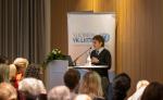 Silvia puhuu yleisölle korokkeella
