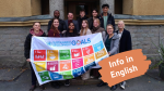 A group of smiling young people hold a big flag of sustainable development goals