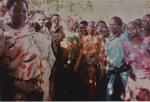 Helena Laukko Luweron naisten ympäröimänä afrikkalaisissa asuissa iloisia ihmisiä