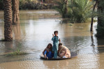 kolme lasta kelluu tulvavedessä kannen päällä