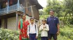 Nepalilainen perhe seisoo kotitalonsa edessä